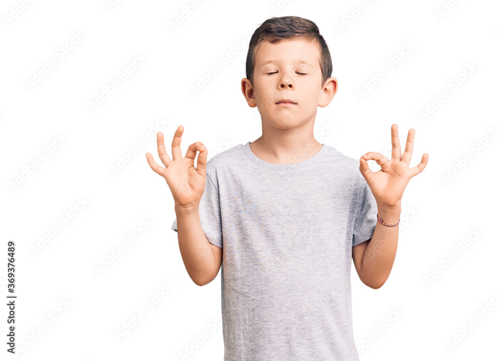 Cute blond kid wearing casual clothes relax and smiling with eyes closed doing meditation gesture with fingers. yoga concept. Cute blond kid wearing casual clothes relax and smiling with eyes closed doing meditation gesture with fingers. yoga concept.