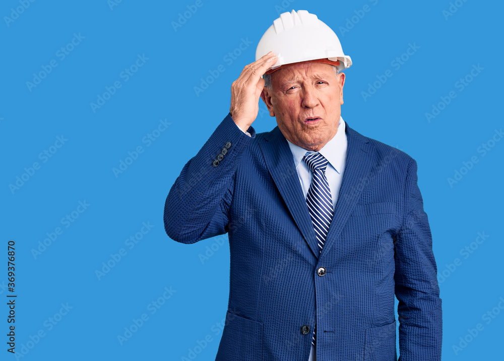 Senior handsome grey-haired man wearing suit and architect hardhat confuse and wonder about question. uncertain with doubt, thinking with hand on head. pensive concept. Senior handsome grey-haired man wearing suit and architect hardhat confuse and wonder about question. uncertain with doubt, thinking with hand on head. pensive concept.