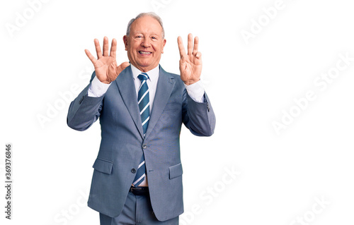 Senior handsome grey-haired man wearing elegant suit showing and pointing up with fingers number eight while smiling confident and happy.