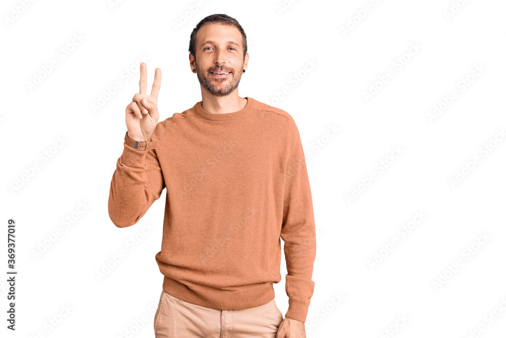 Naklejka premium Young handsome man wearing casual clothes showing and pointing up with fingers number two while smiling confident and happy.