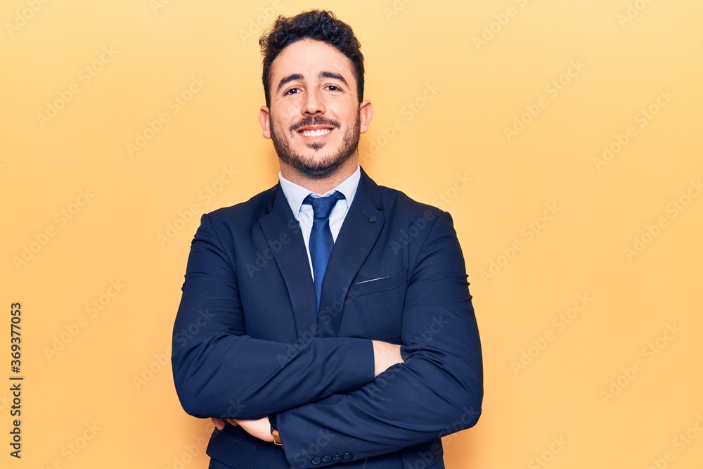 Young hispanic man wearing suit happy face smiling with crossed arms looking at the camera. positive person. Young hispanic man wearing suit happy face smiling with crossed arms looking at the camera. positive person.