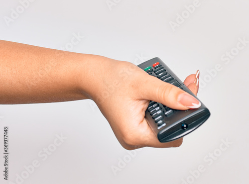 Wallpaper Mural Hand of caucasian young woman changing television channel holding tv remote control over isolated white background Torontodigital.ca