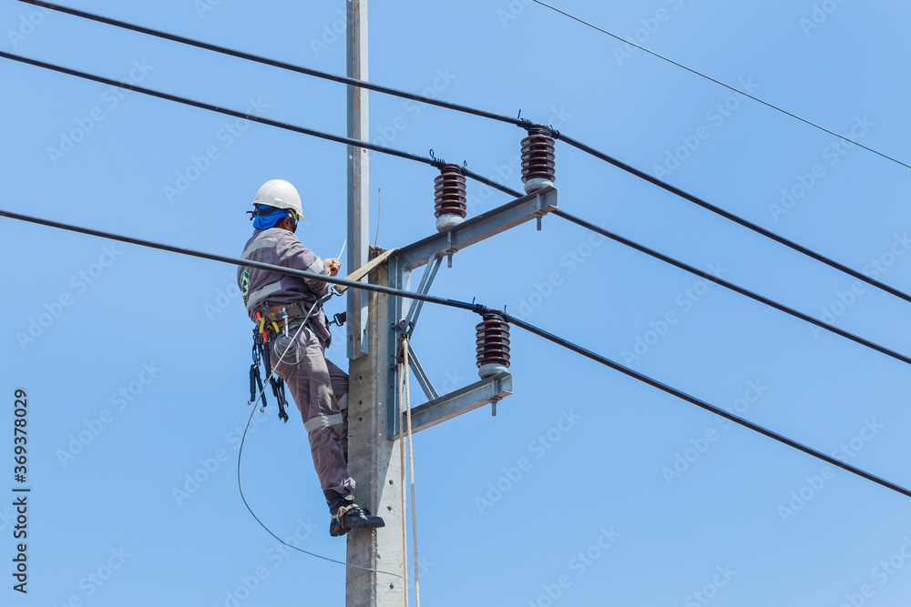 Electricians Wiring Cable repair services,worker in crane truck bucket  fixes high voltage power transmission line,setting up the power line wire  on electric power pole. Stock Photo