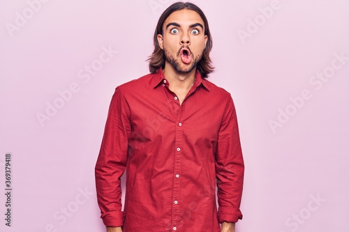 Young handsome man wearing business clothes afraid and shocked with surprise expression, fear and excited face.