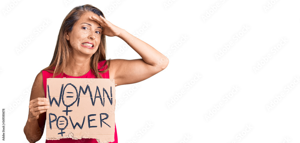 Middle age hispanic woman holding woman power banner stressed and frustrated with hand on head, surprised and angry face Middle age hispanic woman holding woman power banner stressed and frustrated with hand on head, surprised and angry face