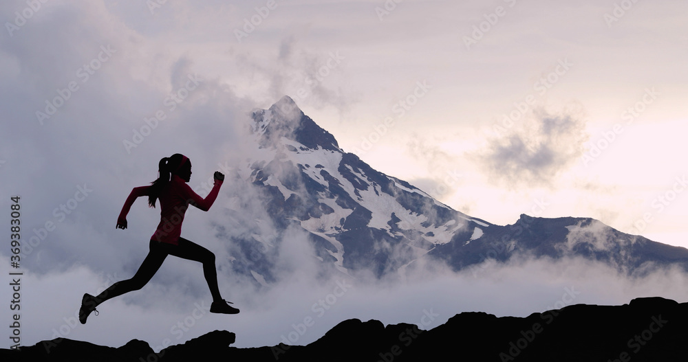 Running woman athlete sport concept. Trail runner exercising in mountain summit background. Female runner on run training outdoors living active fit lifestyle. Silhouette at sunset. - obrazy, fototapety, plakaty 
