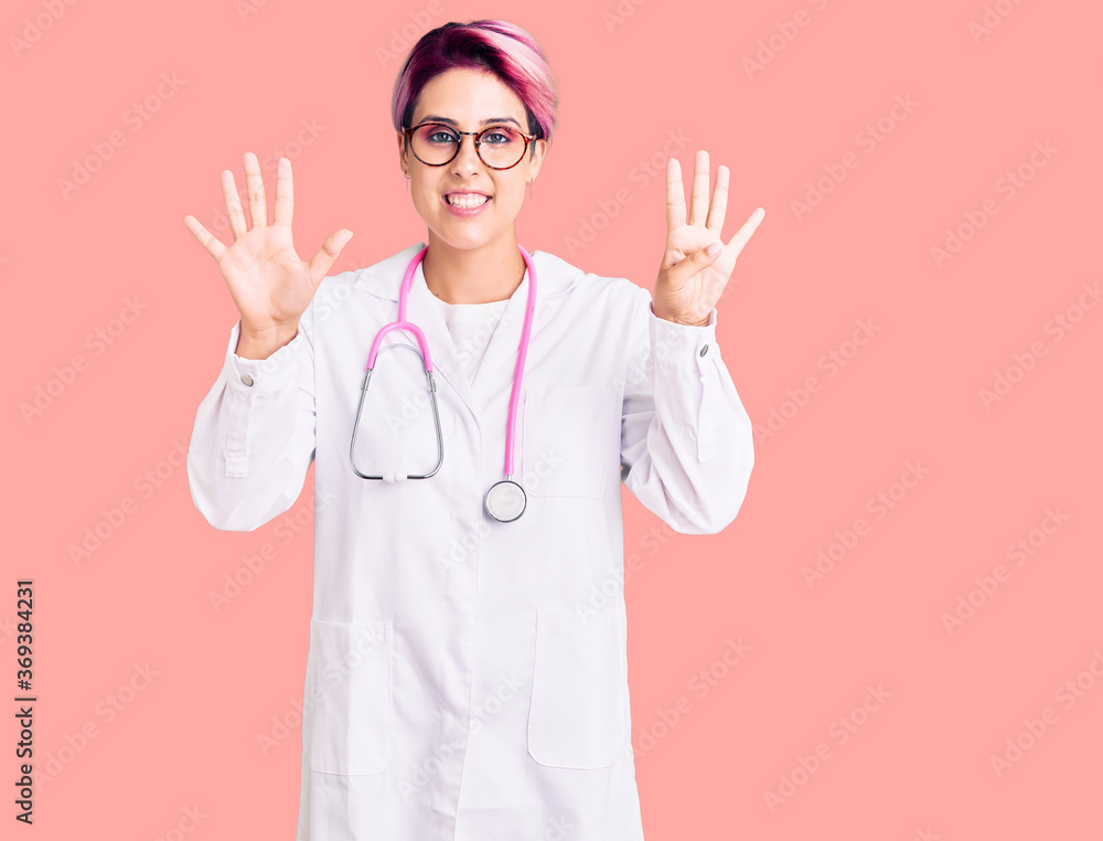 Young beautiful woman with pink hair wearing doctor uniform showing and pointing up with fingers number nine while smiling confident and happy. Young beautiful woman with pink hair wearing doctor uniform showing and pointing up with fingers number nine while smiling confident and happy.