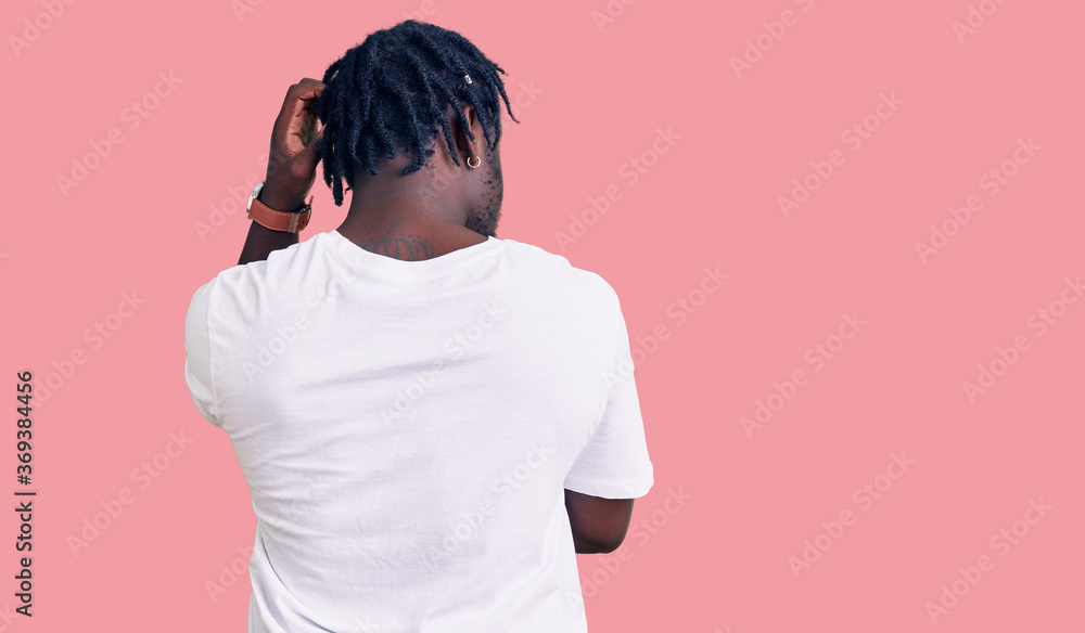 Young african american man with braids wearing casual white tshirt backwards thinking about doubt with hand on head Young african american man with braids wearing casual white tshirt backwards thinking about doubt with hand on head