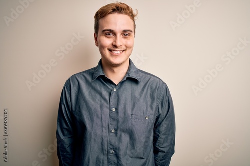 Young handsome redhead man wearing casual shirt standing over isolated white background with a happy and cool smile on face. Lucky person. © Krakenimages.com