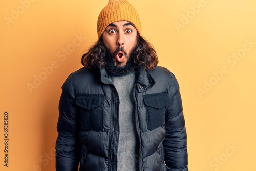 Young arab man wearing casual winter clothes scared and amazed with open mouth for surprise, disbelief face © Krakenimages.com