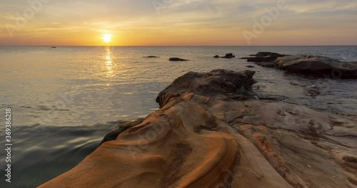 Time lapse: Sunset view on the ocean with reflection and silhouette. A beached foreground log adds interest. Slow motion timelapse 4K footage. Shot at 2160p.