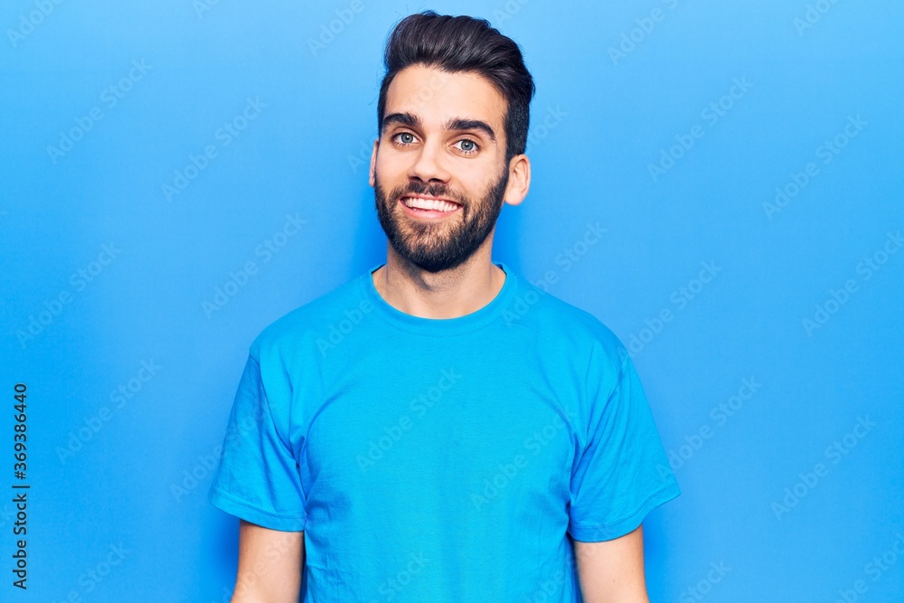 Young handsome man with beard wearing casual t-shirt with a happy and cool smile on face. lucky person. Young handsome man with beard wearing casual t-shirt with a happy and cool smile on face. lucky person.