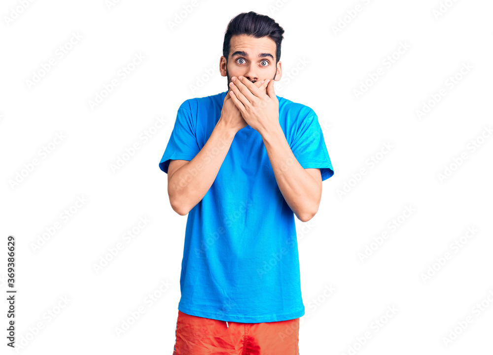 Young handsome man with beard wearing casual t-shirt shocked covering mouth with hands for mistake. secret concept. Young handsome man with beard wearing casual t-shirt shocked covering mouth with hands for mistake. secret concept.