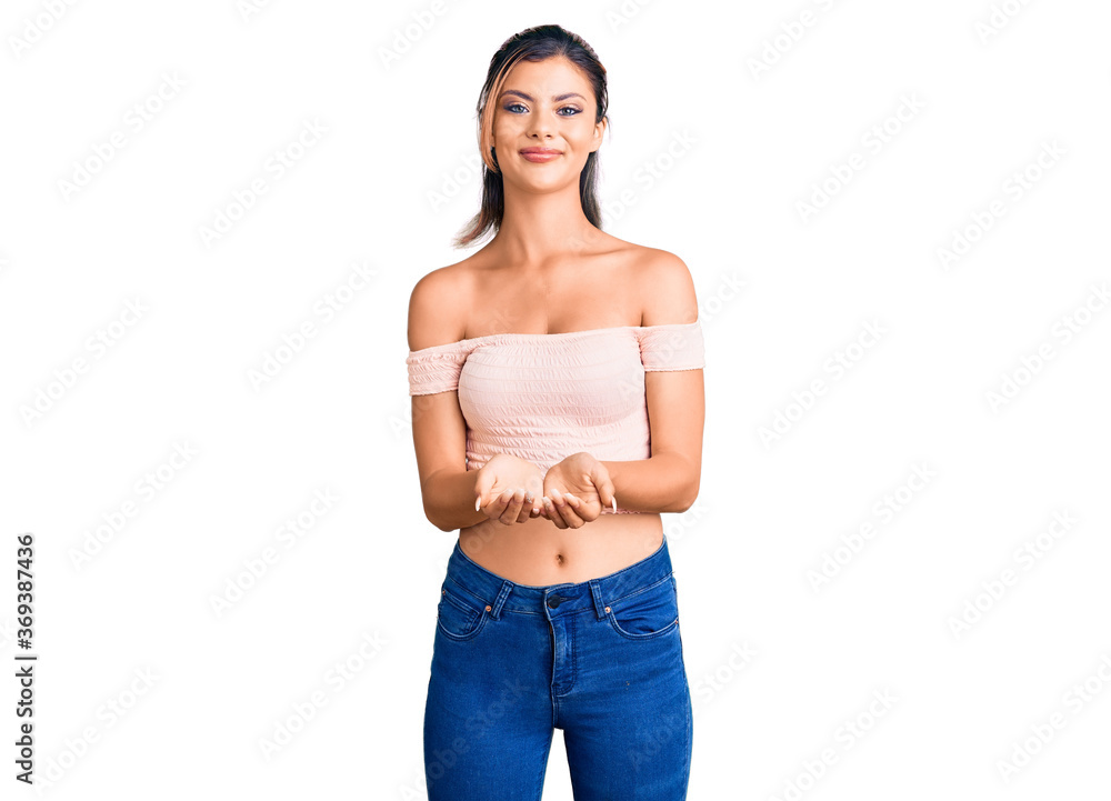 Young beautiful woman wearing casual clothes smiling with hands palms together receiving or giving gesture. hold and protection Young beautiful woman wearing casual clothes smiling with hands palms together receiving or giving gesture. hold and protection