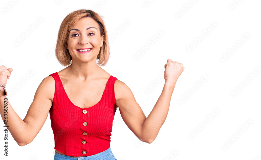 Young blonde woman wearing casual clothes screaming proud, celebrating victory and success very excited with raised arms Young blonde woman wearing casual clothes screaming proud, celebrating victory and success very excited with raised arms