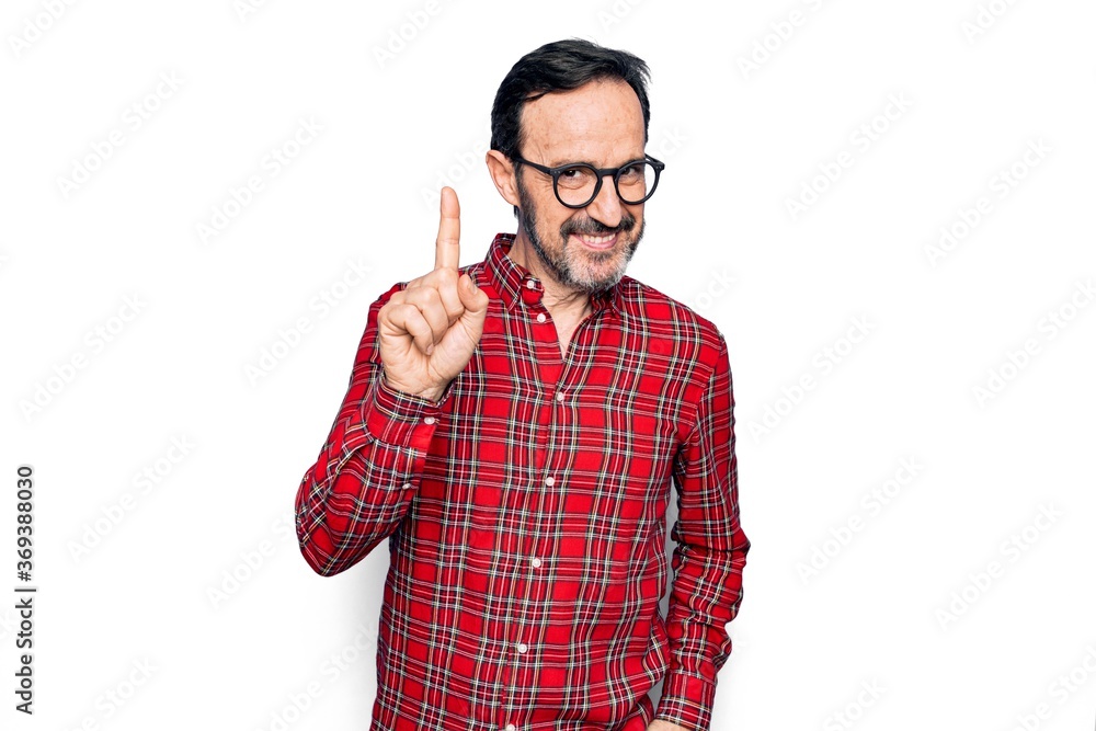 Middle age handsome man wearing casual shirt and glasses over isolated white background smiling with an idea or question pointing finger up with happy face, number one Middle age handsome man wearing casual shirt and glasses over isolated white background smiling with an idea or question pointing finger up with happy face, number one