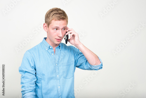 Portrait of young handsome blond businessman talking on the phone