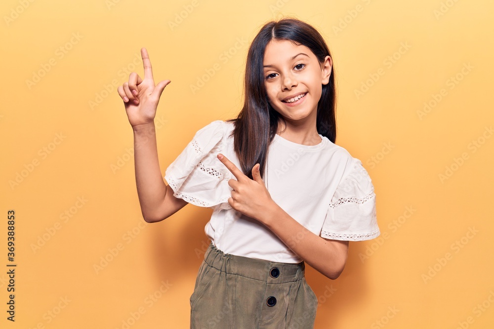 Beautiful child girl wearing casual clothes smiling and looking at the camera pointing with two hands and fingers to the side. Beautiful child girl wearing casual clothes smiling and looking at the camera pointing with two hands and fingers to the side.