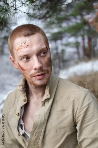 young man in a world war II uniform in a winter forest