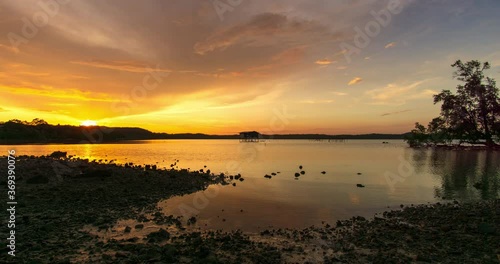 Time lapse: Sunset view on the ocean with reflection and silhouette. A beached foreground log adds interest. Slow motion timelapse 4K footage. Shot at 2160p.