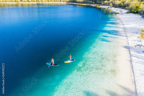Obraz na plátne Couple stand up paddle boarding  on Lake Mckenzie