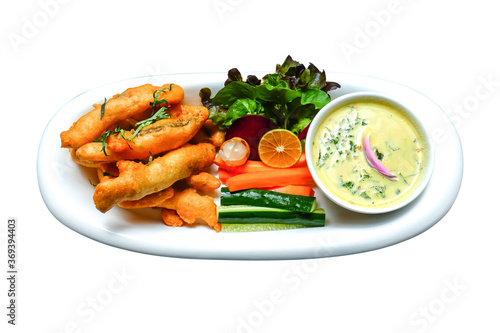 Fried fish sticks with coconut milk sauce and some vegetables decoration in plate isolated on white background. Fish fly in sticks decorative in dish with white sauce cream and vegetable