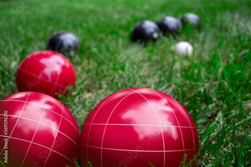 Obraz na plátne Italian bocce ball, bocci or boccie red and blue white balls on green lawn close up