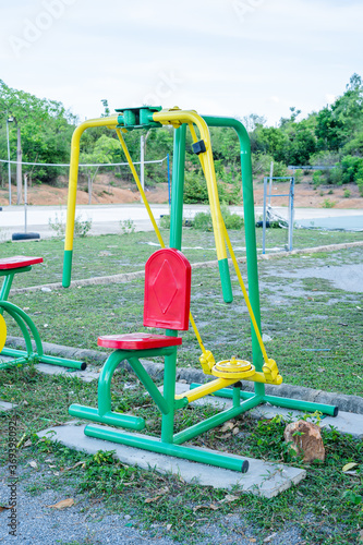 Red, Green Exercise Equipment, Arms, Chest Press outdoors in the stadium In the midst of nature