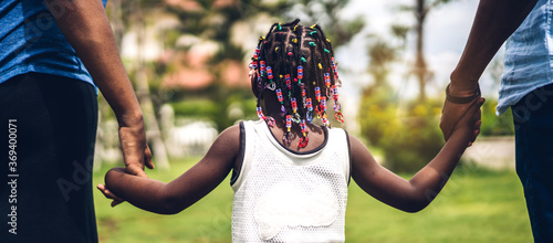 Portrait of enjoy happy love black family african american father and mother holding little african girl hand in moments good time in summer park at home