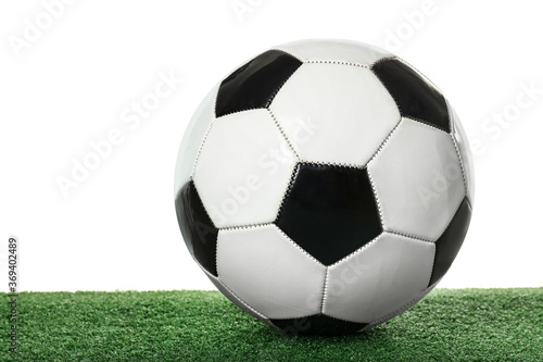 Soccer ball on green field against white background