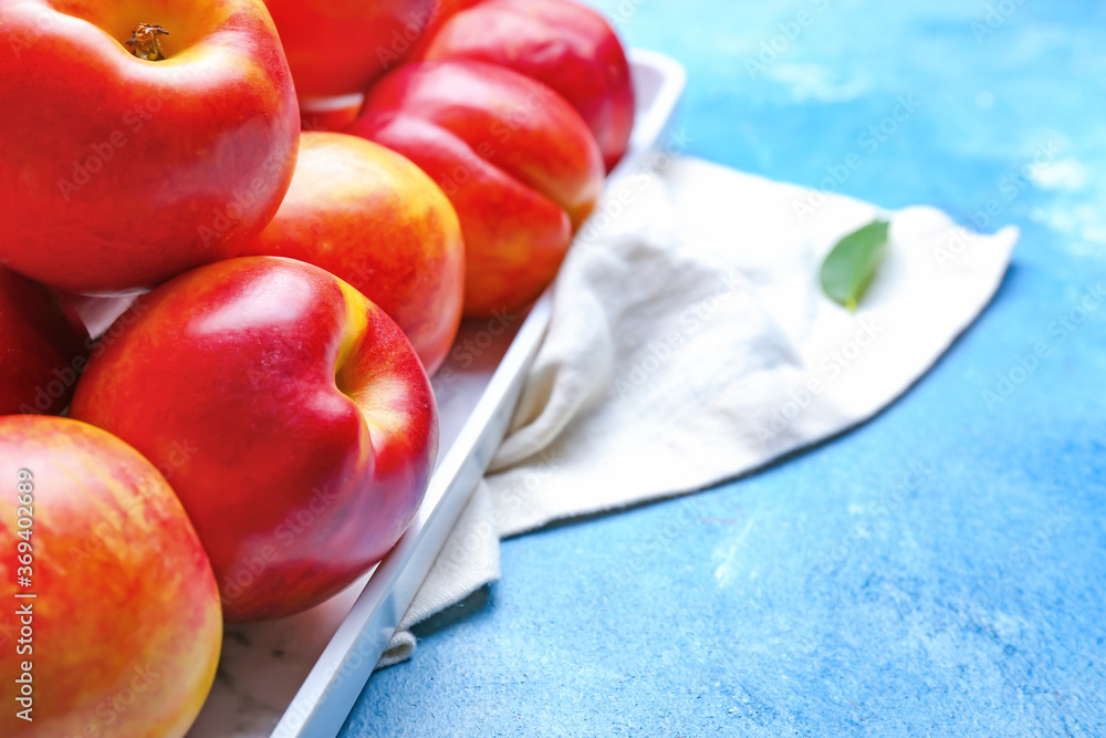 Tray with sweet ripe nectarines on color background, closeup Tray with sweet ripe nectarines on color background, closeup