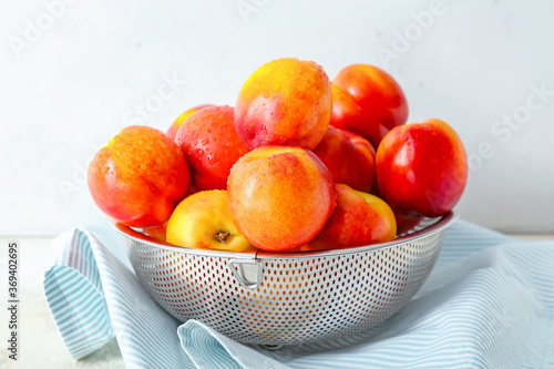 Fototapeta Naklejka Na Ścianę i Meble -  Sweet ripe nectarines in colander on table