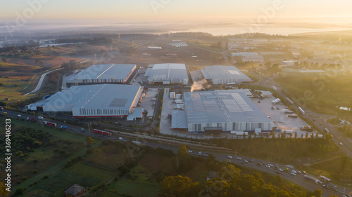 фотографія Industrial logistics warehouses with the sun rising an mist in the background
