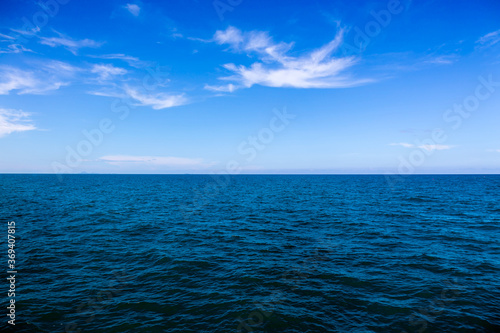 Water surface with Deep Blue sea and clear sky clouds. Landscape with Ocean small waves water reflection. Illustration for tourism, website or advertisement. Andaman sea, Thailand.