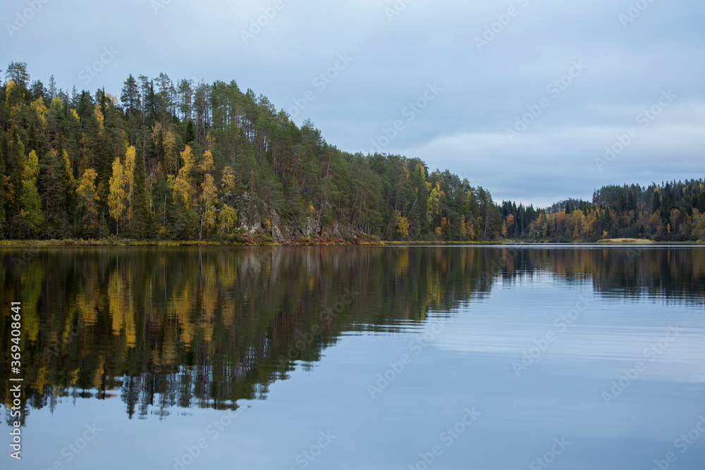 Reflection of colorful trees on a lake surface during autumn foliage near Kuusamo, Finland, northern Europe