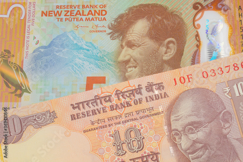A macro image of a orange ten rupee bill from India paired up with a orange, plastic five dollar bill from New Zealand.  Shot close up in macro.