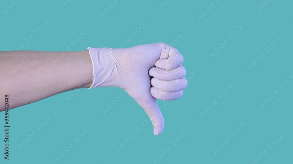 Close-up shot of man's gloved hand demonstrating dissatisfaction, irritation, disapproval of service, continually showing thumb down at camera.Isolated on blue background.Human emotions concept. Close-up shot of man's gloved hand demonstrating dissatisfaction, irritation, disapproval of service, continually showing thumb down at camera.Isolated on blue background.Human emotions concept.