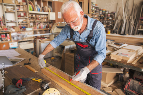 Carpenter measuring a plank of wood