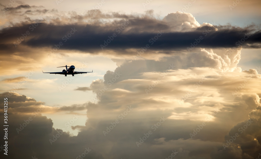 Silhouette of business jet landing on the background of sunset Silhouette of business jet landing on the background of sunset