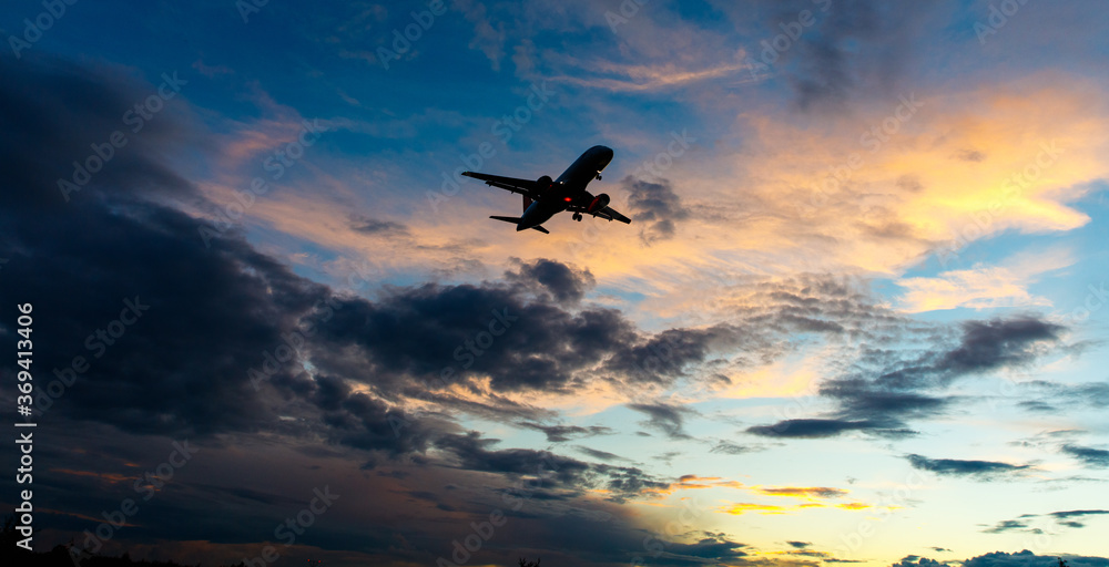 A passenger plane comes in for landing against the background of the evening sky