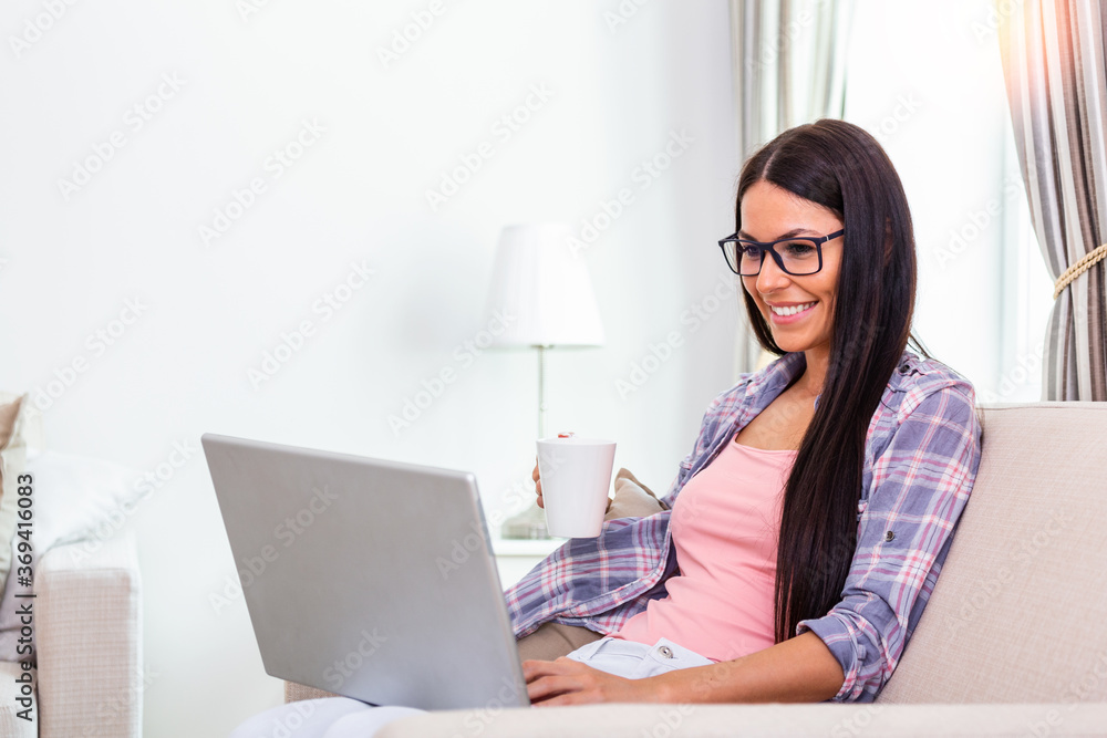Beautiful woman freelancer noting information for planning project doing remote job via laptop computer. Girl laughing while reading email on modern laptop device . Beautiful woman freelancer noting information for planning project doing remote job via laptop computer. Girl laughing while reading email on modern laptop device .