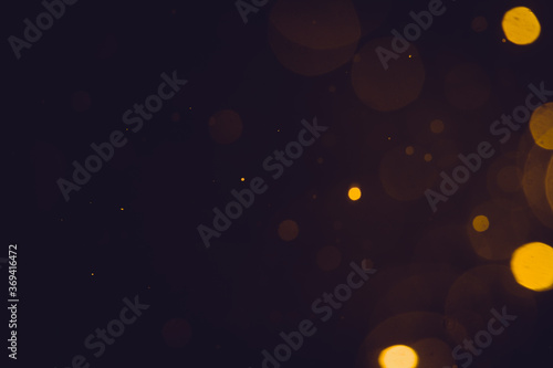 Dark Abstract Gold bokeh sparkle on black background © pandaclub23