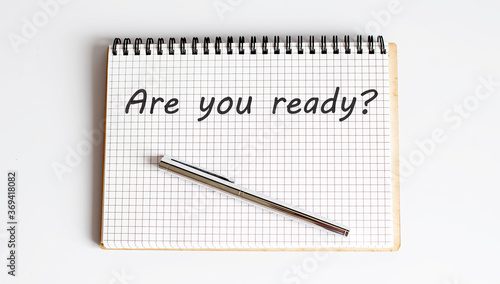 Are You Ready Text written on notebook page with pen.Motivational business Concept image