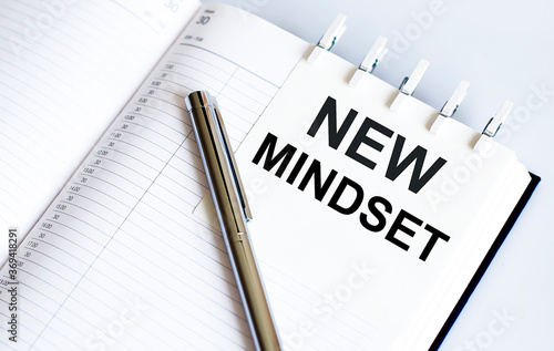 text NEW MINDSET on the short note texture background with pen