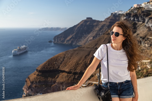 Happy smiling woman tourist traveling on luxury cruise in Mediterranean, Greece, Santorini. Background architecture island sea sky