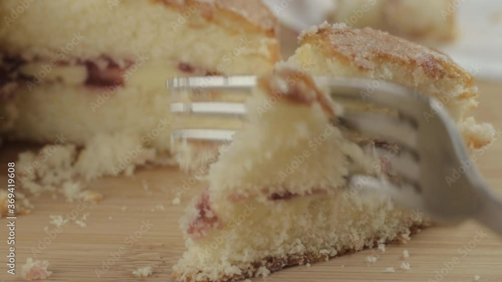 Eating slice of Victoria sponge cake with fork macro shot Eating slice of Victoria sponge cake with fork macro shot