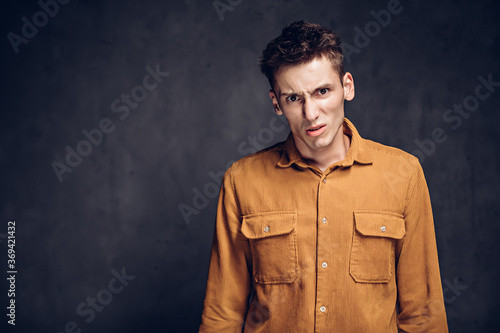 Dissatisfied young caucasian man on dark background