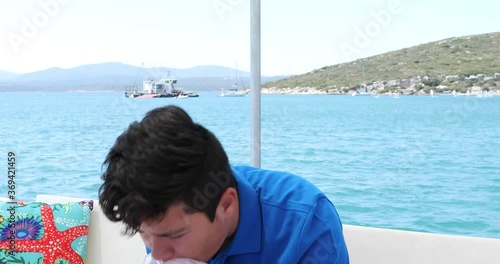Young boy having a nausea seasickness during the boat trip