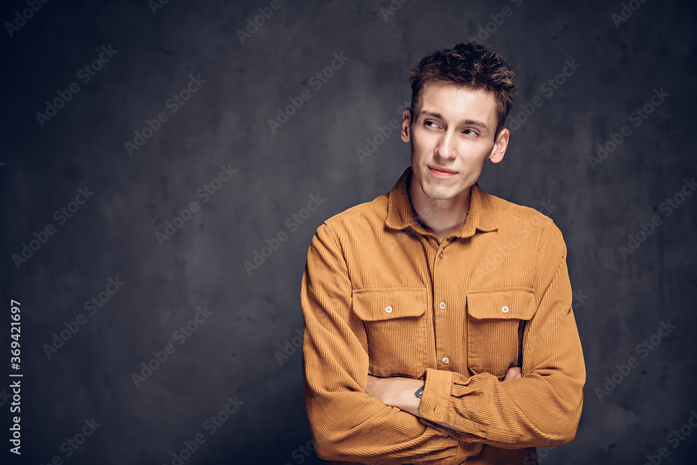 Sly young caucasian man on dark background