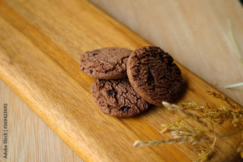chocolate cookies and dark chocolate grain on wooden board background. for text concept advertising chocolate cookies and dark chocolate grain on wooden board background. for text concept advertising